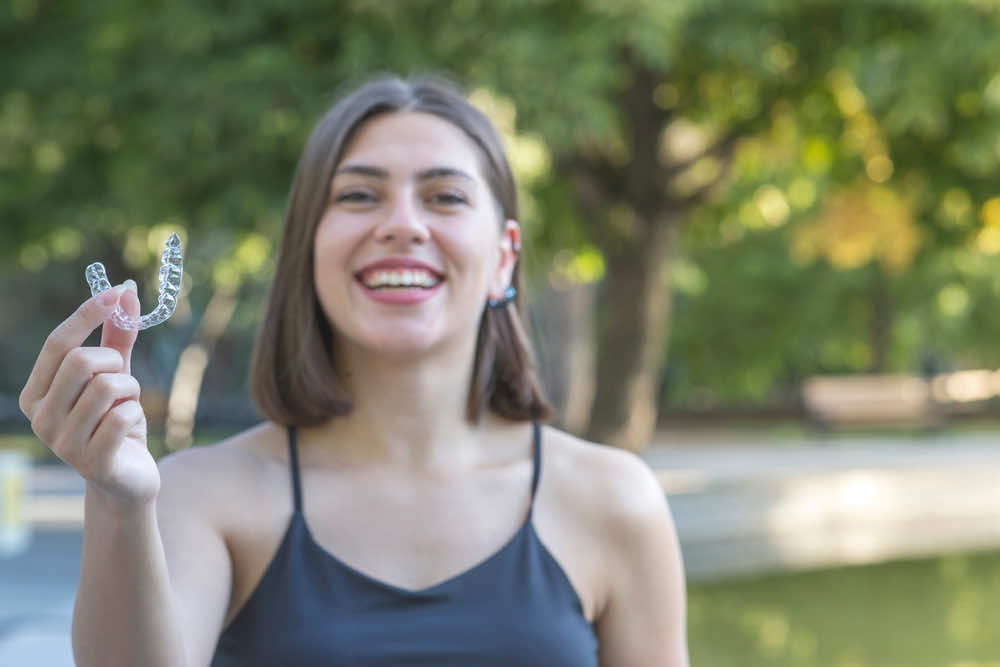girl-holding-a-clear-ortho-aligner